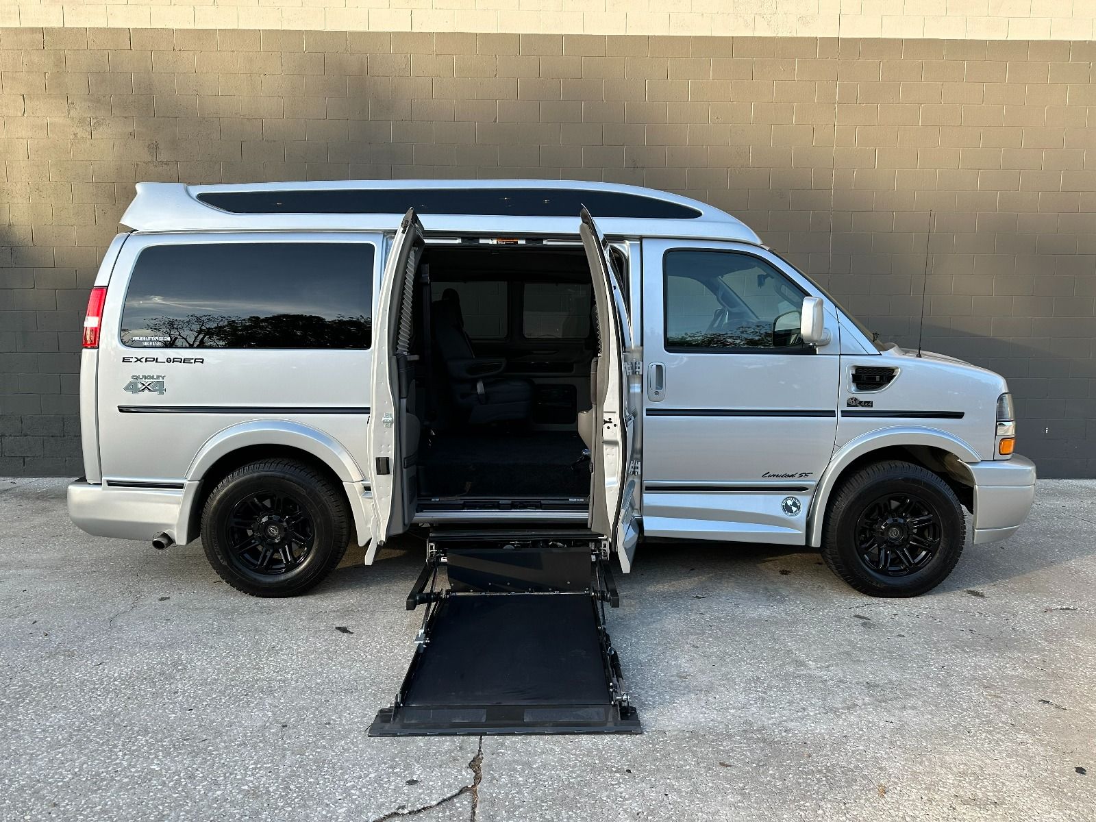 Chevrolet Express Full Size Wheelchair Van with lift deployed from open passenger side barn doors.