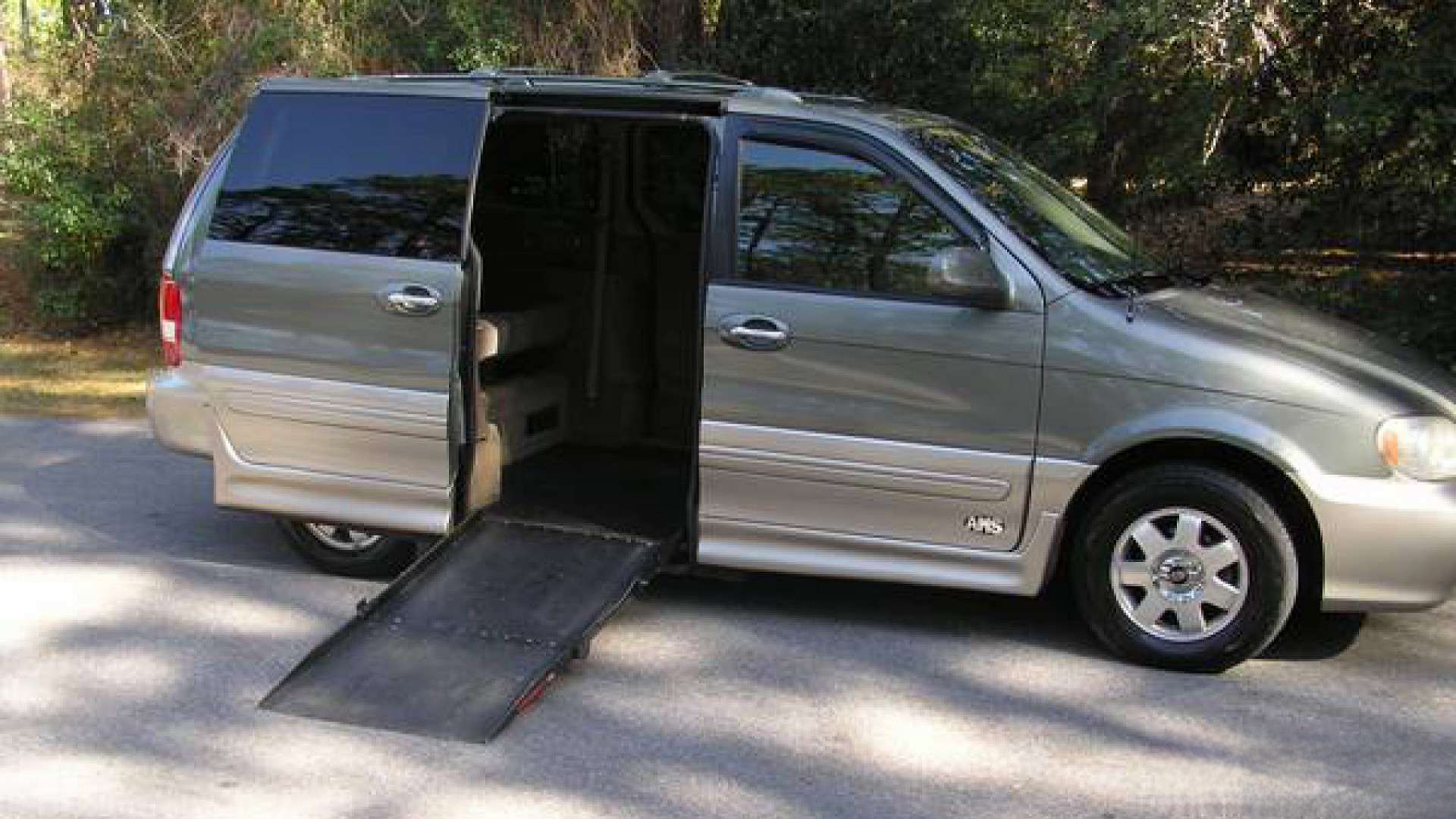 Green Kia Sedona Wheelchair Van with ramp deployed